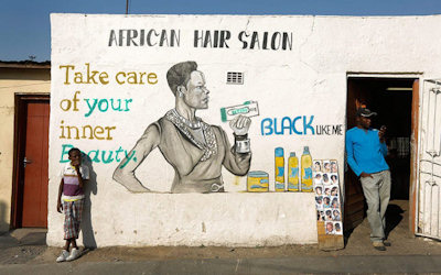 Exterior of African hair salon with mural that reads Take care of your inner beauty