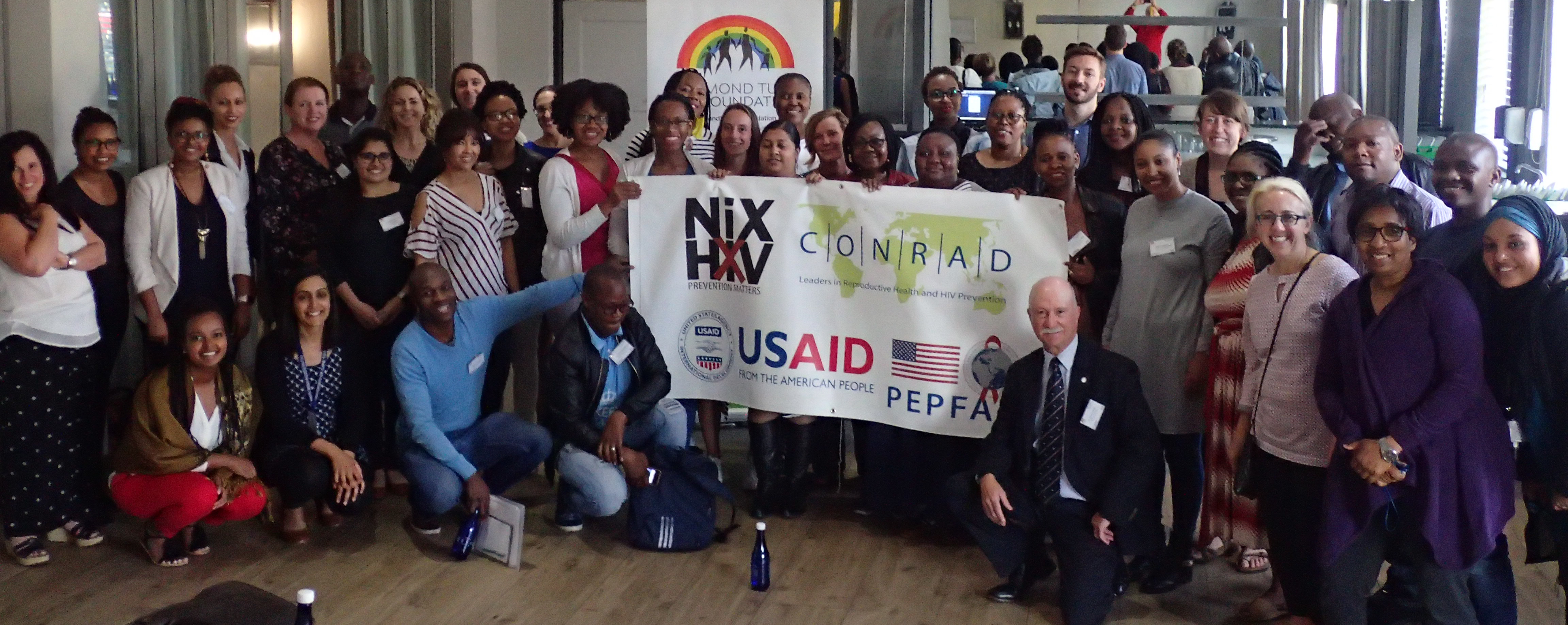 A group of people around a NIX HIV banner.